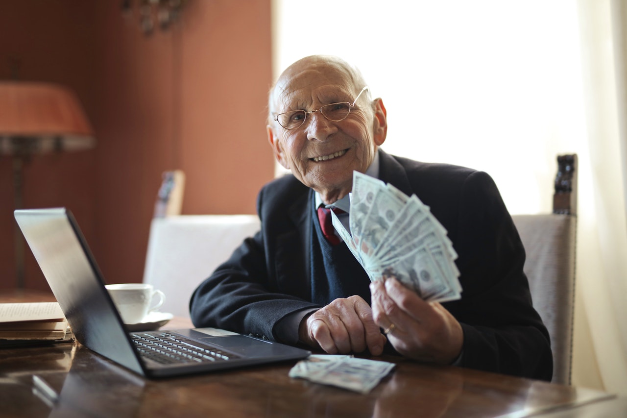 Old man showing his money from online gambling winnings